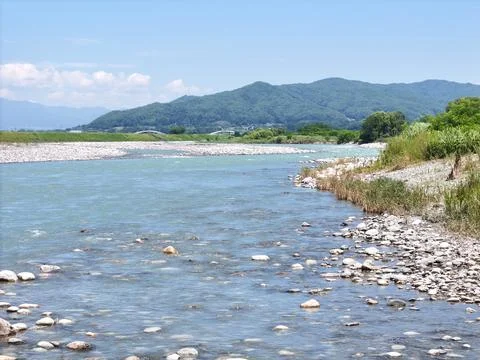 Clear river flows gently through rocky bed Stock Photos