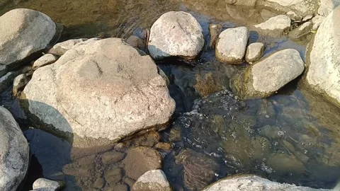 Clear river stream flowing around large stones and boulders 스톡 동영상 344087618