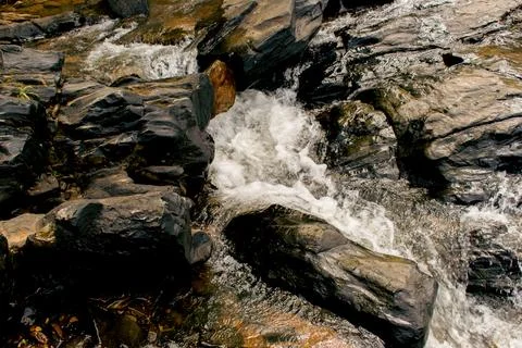 Clear river stream flowing between the rocks. Stock Photos