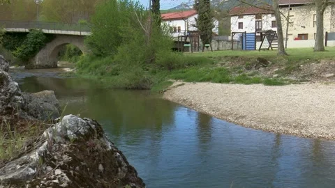 Clear River Water Flowing Beneath Historic Stone Bridge in Natural Landscape Stock Footage 330338329