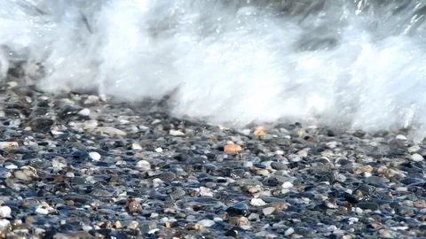 The clear sea breaks on the pebble beach on a beautiful sunny day Stock Footage 88038913