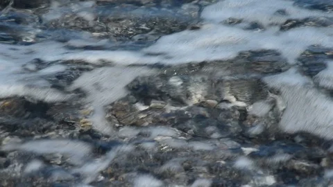 The clear sea breaks on the pebble beach on a beautiful sunny day Video stock 88039532