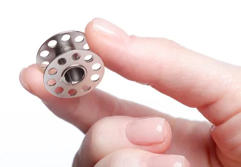 Clear sewing machine bobbins spool in hand Stock Photos