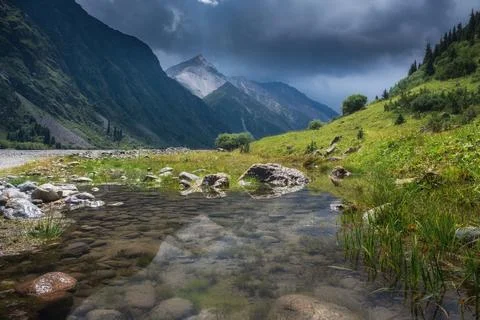 A clear shallow river stream in the Bayankol Valley of Kazakhstan with grassy 库存照片