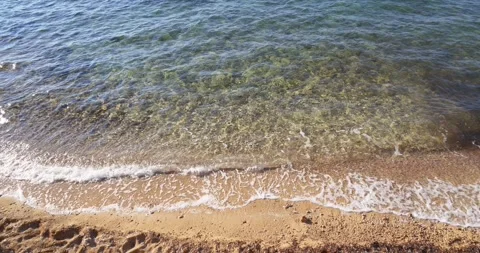 Clear shallow sea water gently washes onto sandy beach shore Stock Footage 337415966