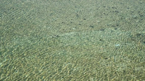 Clear Shallow Water Surface With Visible Ripples and Pebbles Stock Footage 335983216