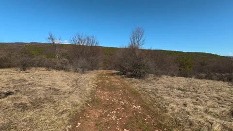 Clear sky above dry grass and winding path. Balkan, Eastern Europe, POV Vídeos de archivo 331780736