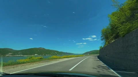 Clear sky above winding road beside lake. Balkan, Eastern Europe, POV Video stock 333345594