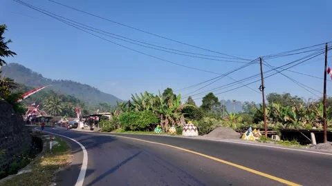 Clear sky above winding road through village Stock Footage 345143727