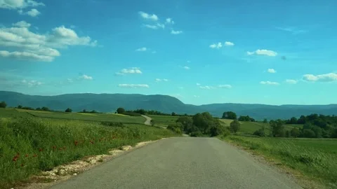 Clear sky above winding rural road through green fields. Balkans, Serbia Stock Footage 338025977