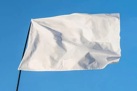Clear sky background, white flag with frayed edges, rectangular sections, n.. Stock Photos