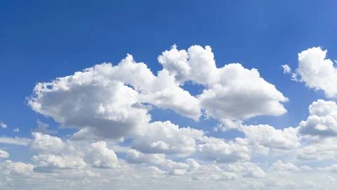 Clear sky with cumulus clouds. Blue sky frames white clouds. Bright sky con.. Stock Photos