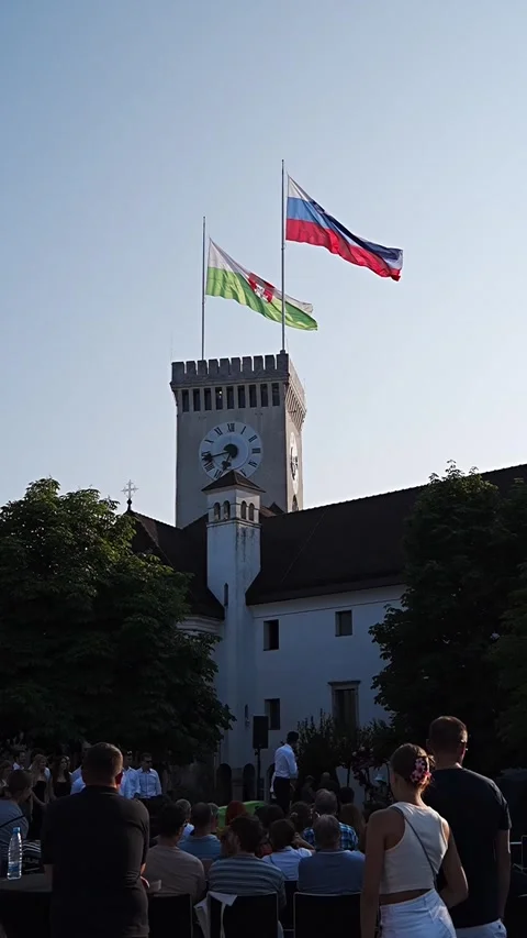 Clear sky over historic clock tower with flags Stock Footage 345538877