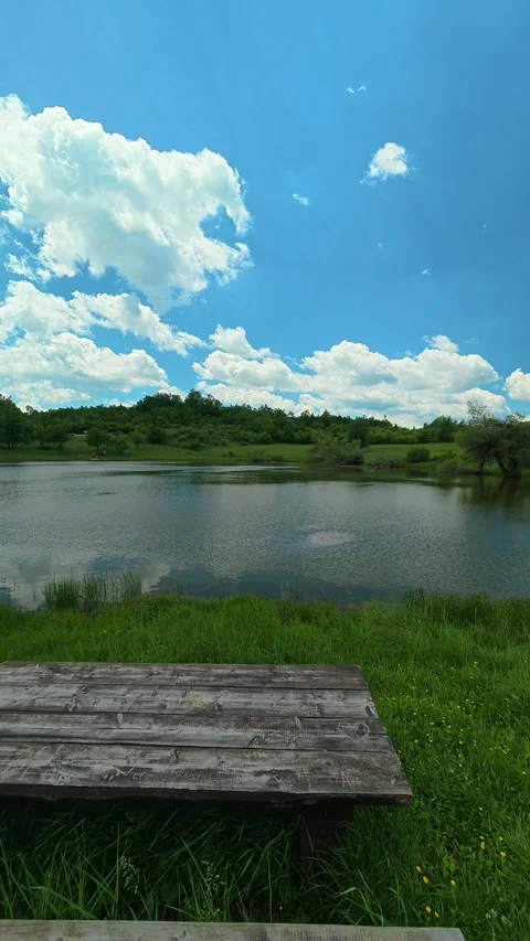 Clear sky reflects on calm lake surface. Vrmdza Lake, Serbia. Vertical Stock Footage 338029533