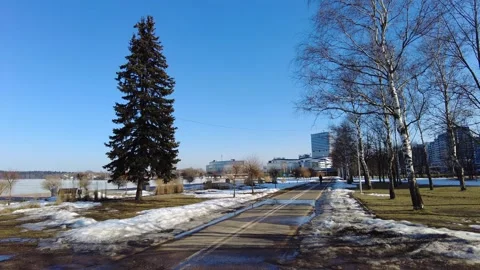 Clear sky view of a park along the lake during late winter with melting snow on Stock Footage 332565335