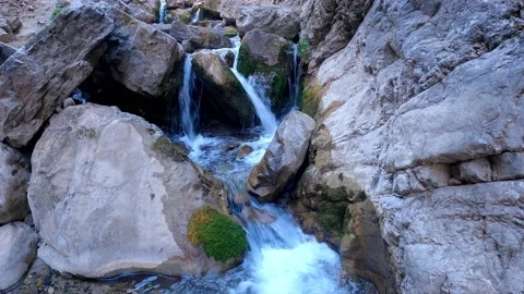 Clear snow water flowing between large and small rocks Stock Footage 171444852