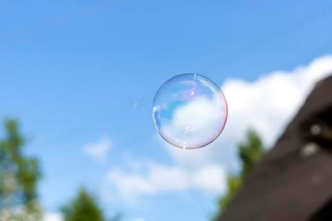 Clear soap bubble in blue cloudy sky 스톡 사진