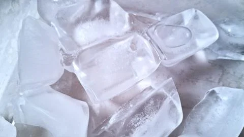 Clear square ice cubes resting on a smooth bright surface Stock Photos