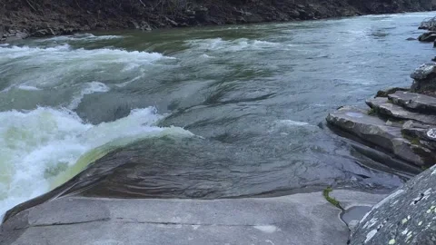 A clear stream flowing through stone boulders in the mountains. Stock Footage 251536806