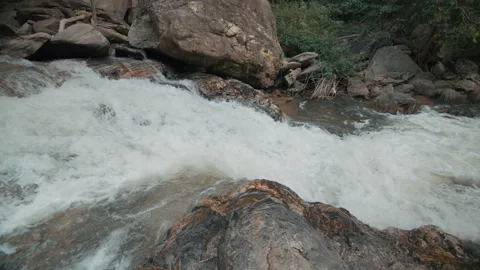 Clear stream running through stone boulders Abundant river flowing on stone Stock Footage 241236919