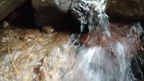 Clear Stream Water Cascading Between Large River Rocks Stock Footage 329783452