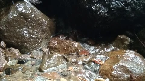 Clear Stream Water Flowing Between Rocks in Natural Outdoor Setting Stock Footage 329818630