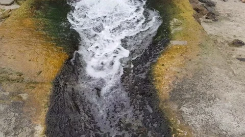 Clear stream of water runs down a concrete 스톡 동영상 153686774