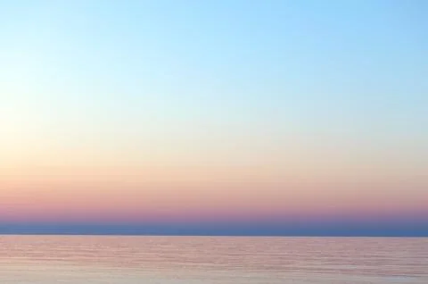 Clear sunset sky. Gradient background in pastel colors. Sunset over the sea. Stock Photos