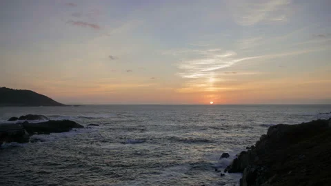 Clear sunset with the sun setting over the horizon accompanied by the moving sea Stock Footage