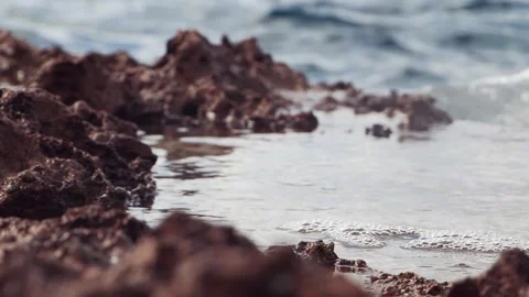 Clear tidal water pools over rugged dark coastal rock formation Stock Footage 337410979