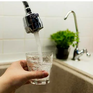 Clear transparent cold water flows from the tap Stock Photos