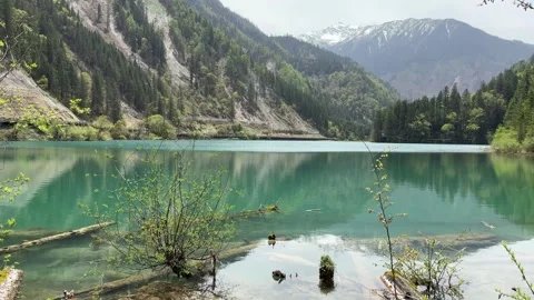 Clear Turquoise Lake Reflecting Mountains in Jiuzhaigou Valley, Sichuan Stockbeeldmateriaal 337328809