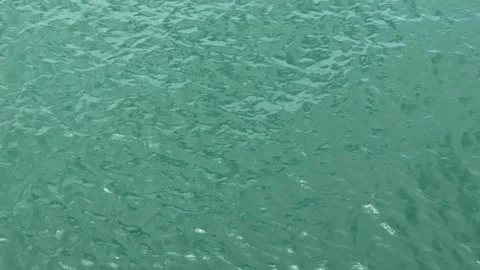 Clear Turquoise Ocean Water Surface Rippling Gently in Sunlight Stock Footage 345714589