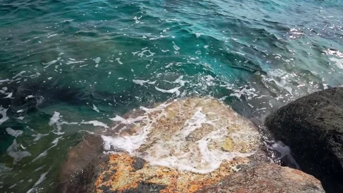 Clear turquoise sea water washing a shiny stone Stock Footage 82807053