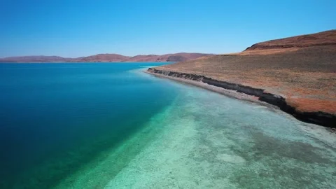Clear turquoise shallows along a curved Yamdrok Lake bank Video stock 345885986
