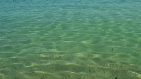Clear turquoise water gently laps sandy beach. Trani Ammouda, Greece Stock Footage 338348023