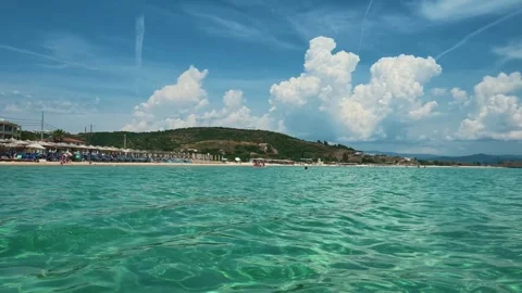 Clear turquoise water gently ripples under sunlit sky. Trani Ammouda, Greece Stock Footage 339618564