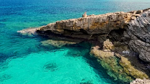 Clear turquoise water gently touching rocky shore at Cala Torta, Mallorca Stock Footage 319856806