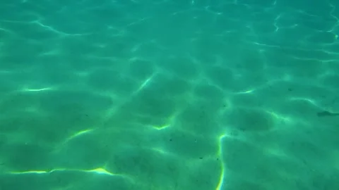 Clear turquoise water glows beneath sunlight. Trani Ammouda, Greece Stock Footage 338347763