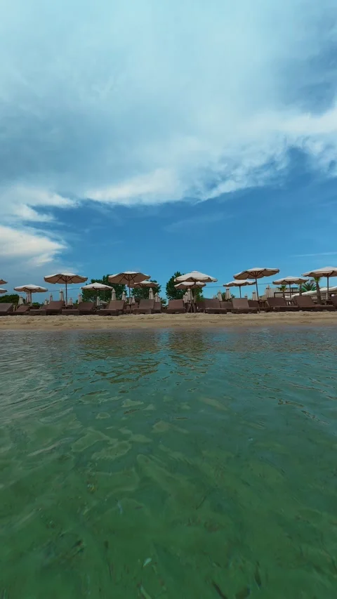 Clear turquoise water laps gently at golden sand. Trani Ammouda, Vertical Stock Footage 340650460