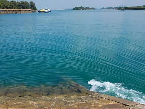 Clear turquoise water ripples gently near stone edge Stock Photos