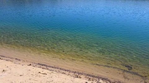 Clear turquoise water on a sandy shore of a calm lake or sea during a sunny day 스톡 동영상 337809105