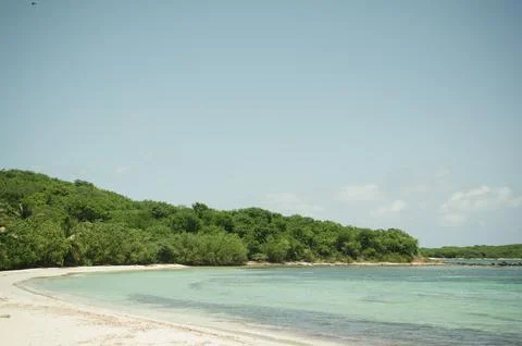 Clear turquoise waters and lush greenery at Playa La Chiva, Vieques Stock-Fotos