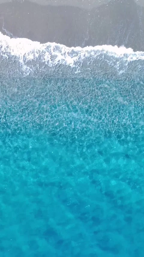 Clear Turquoise Waves Gently Lap Against the Sandy Shore in a Serene Coastal Stock Footage 317750637