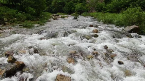 Clear valley water flowing under the caving mountains_3 Stock Footage 280179290