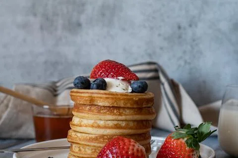 Clear view of Stack of pancakes with honey stick, strawberry, blue berry and  Stock Photos
