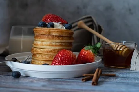 Clear view of Stack of pancakes with honey stick, strawberry, blue berry an.. Stock Photos
