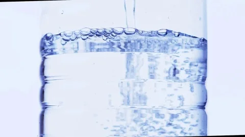 Clear water is being poured to a plastic bottle Stock Footage 73610397