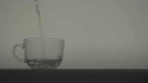 Clear Water Being Poured Into Transparent Cup on White Background Stock Footage 346364124