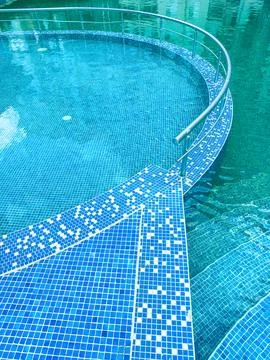 Clear water in a circular pool with a tiled edge and railings in a sunny lo.. 写真素材